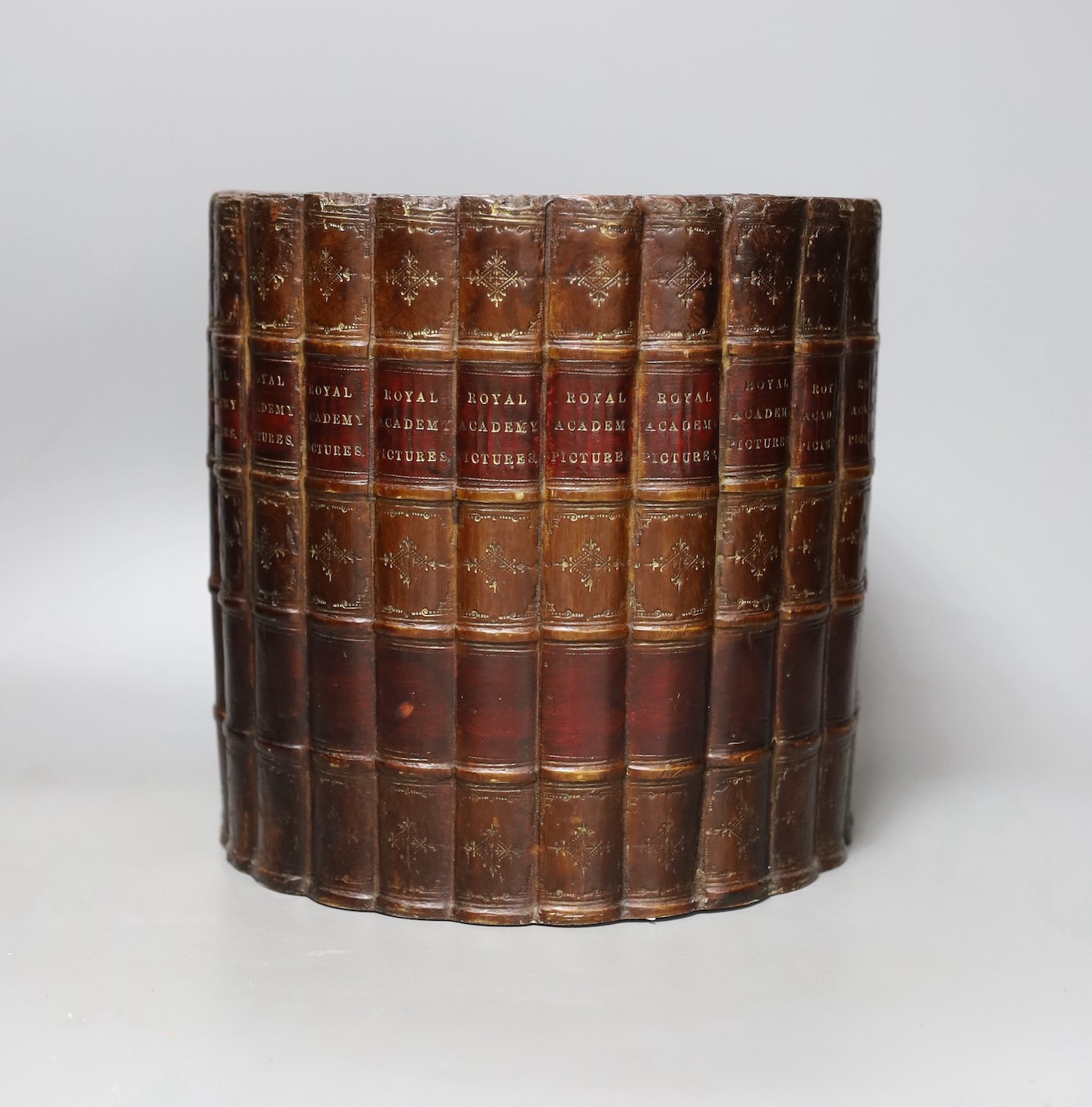A ‘Royal Academy Pictures’ faux book spine waste paper bin, 22cm diameter.